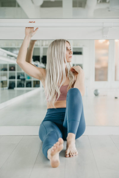 Chelsea, founder and the Why behind Barreroom, sitting in Kelowna Barre studio against mirror wall